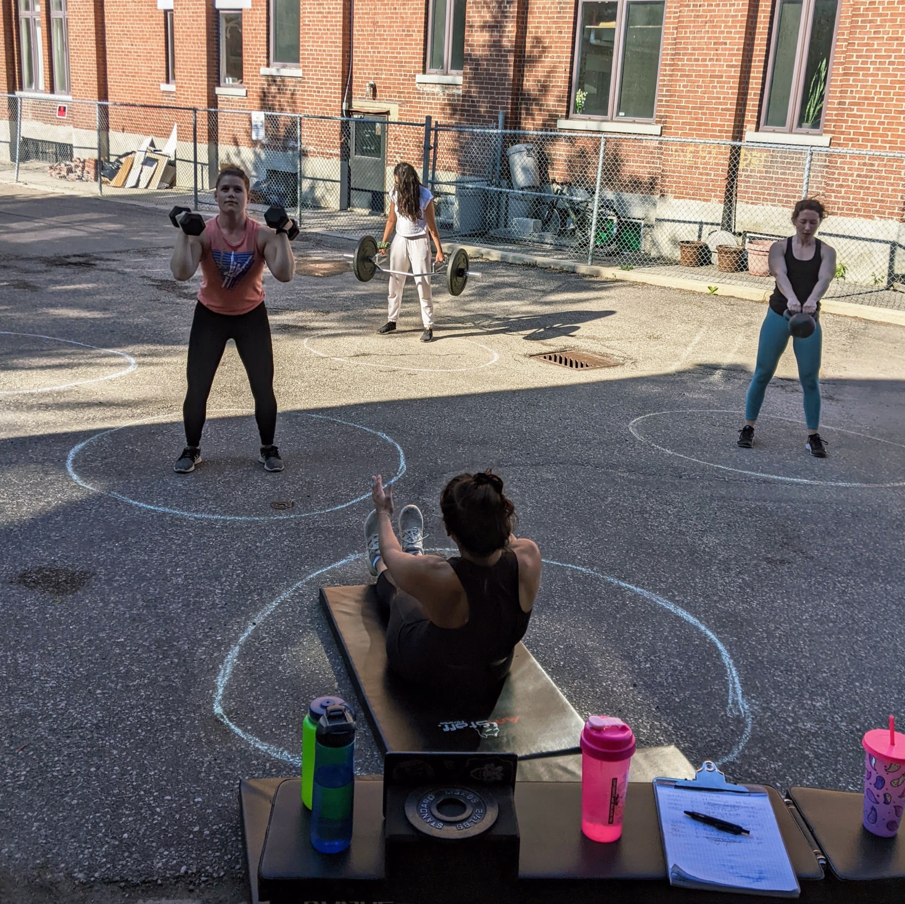 Outdoor group training session with kettlebells and barbells